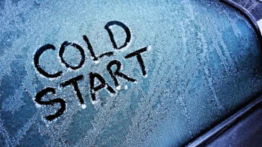 The words "cold start" are drawn on a frozen car window