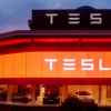 A Tesla showroom with red and white glowing lights at night
