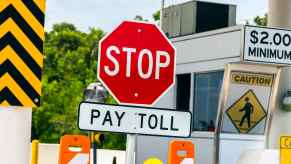 A red stop sign is posted above another sign with the directive "PAY TOLL" on a toll road