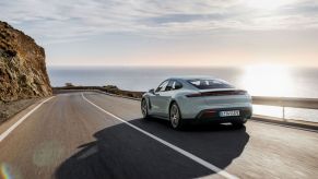 A 2025 Porsche Taycan drives on the coast.