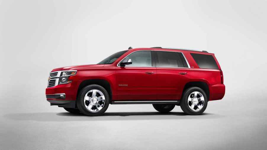A red 2015 Chevrolet Tahoe SUV rendering in left profile view with all-white background