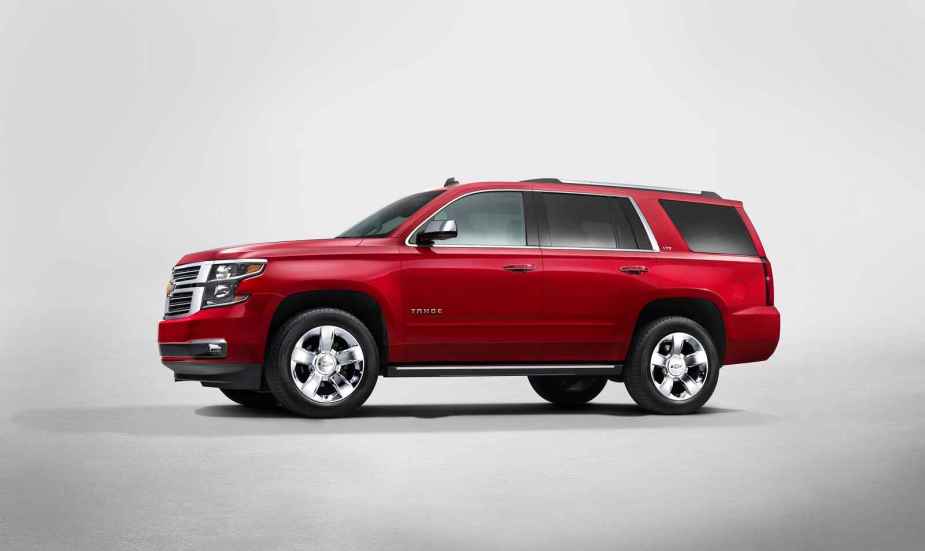 A red 2015 Chevrolet Tahoe SUV rendering in left profile view with all-white background