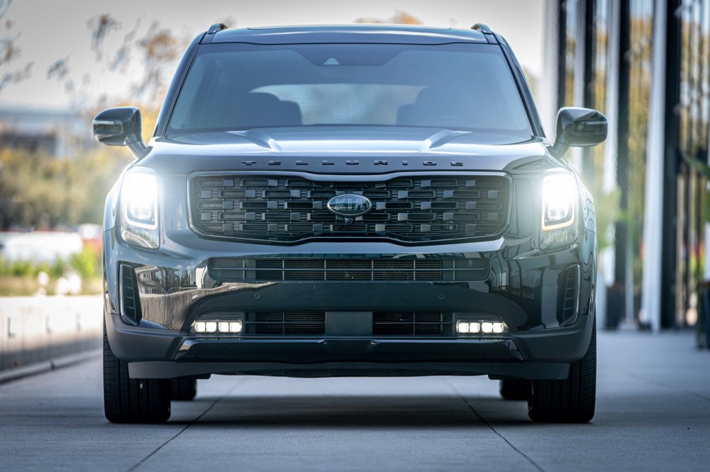 A black 2021 Kia Telluride facing direct front with headlights on