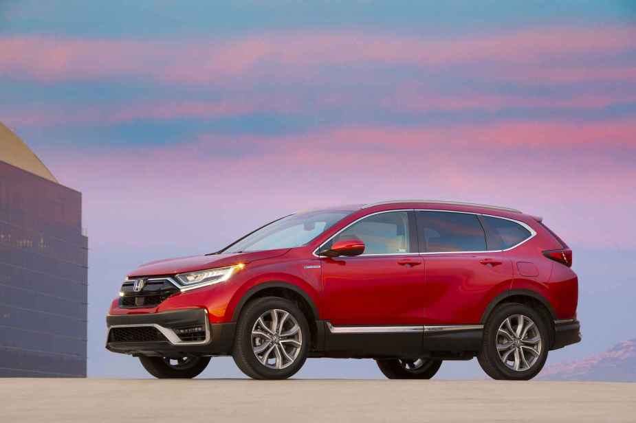 A red 2022 Honda CR-V Hybrid SUV parked with a pink and blue sunset in the background