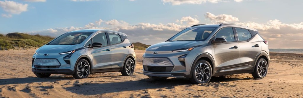 2023 Chevrolet Bolt EV and Bolt EUV  electric cars posed on the sand.