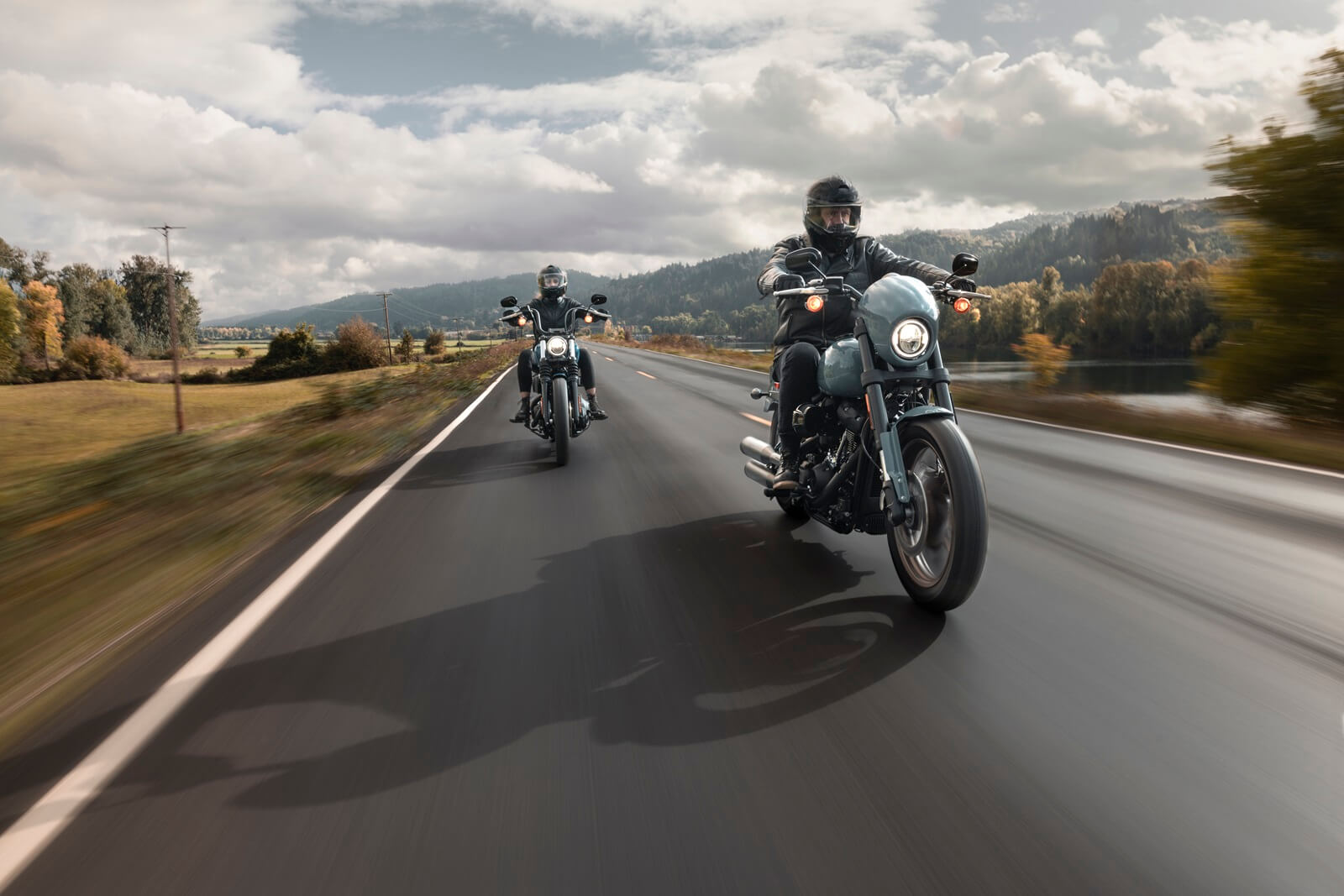 A 2024 Harley-Davidson Softail Street Bob 114 and Low Rider S blast down a highway.