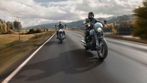A 2024 Harley-Davidson Softail Street Bob 114 and Low Rider S blast down a highway.