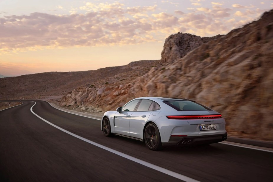 A 2025 Porsche Panamera 4S E-Hybrid shows off its rear-end styling in the desert.