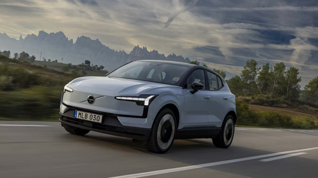 2025 Volvo EX30 compact electric SUV driving on a road.