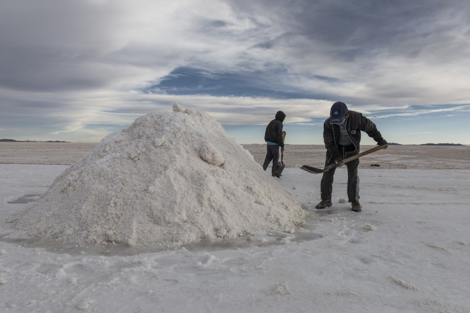 Lithium miners shoveling in salt flats.