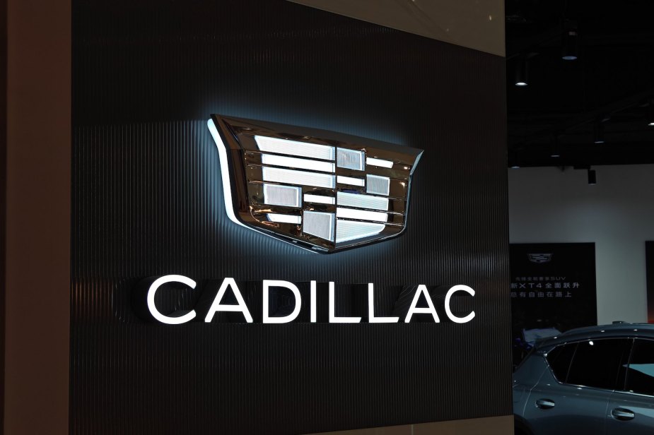 Light-up Cadillac logo and sign at a dealership.