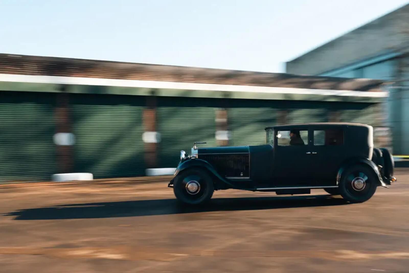 An Electrogenic 1929 Rolls-Royce Phantom II EV conversion belonging to Jason Momoa speeds across an apron. 