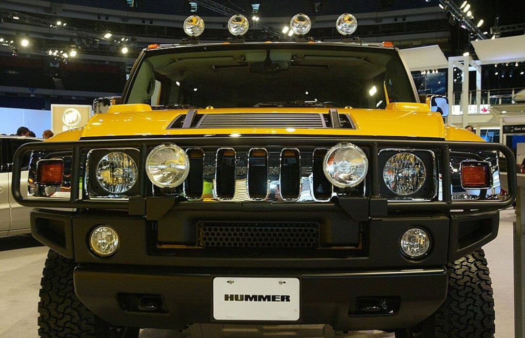 A yellow Hummer H2 at an international auto show.