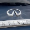 A chrome oval-shaped INFINITI logo and brand name on the back of a crossover.