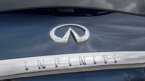 A chrome oval-shaped INFINITI logo and brand name on the back of a crossover.