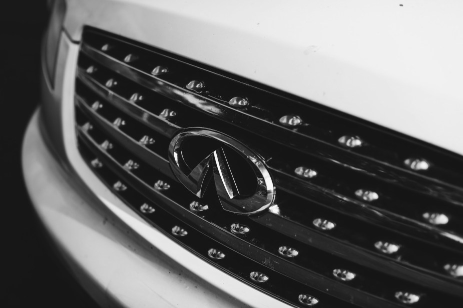 The Infiniti logo on the grille of a luxury automobile. 