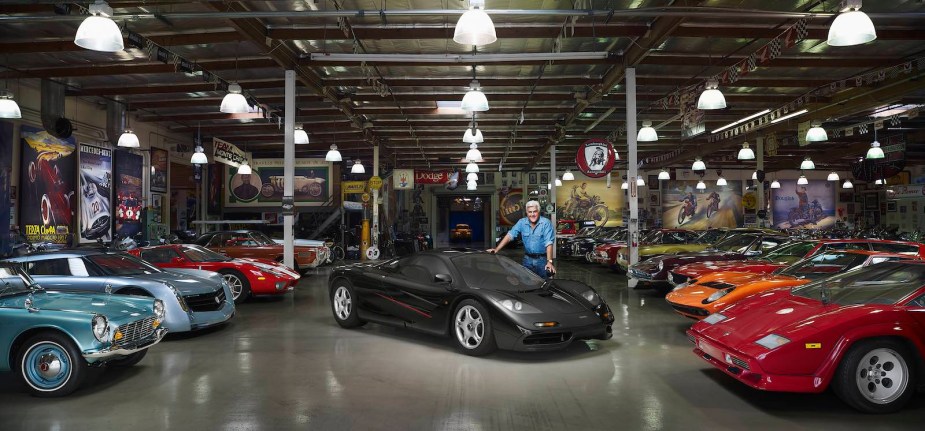 Jay Leno stands by his McLaren P1, in the midst of his car collection.