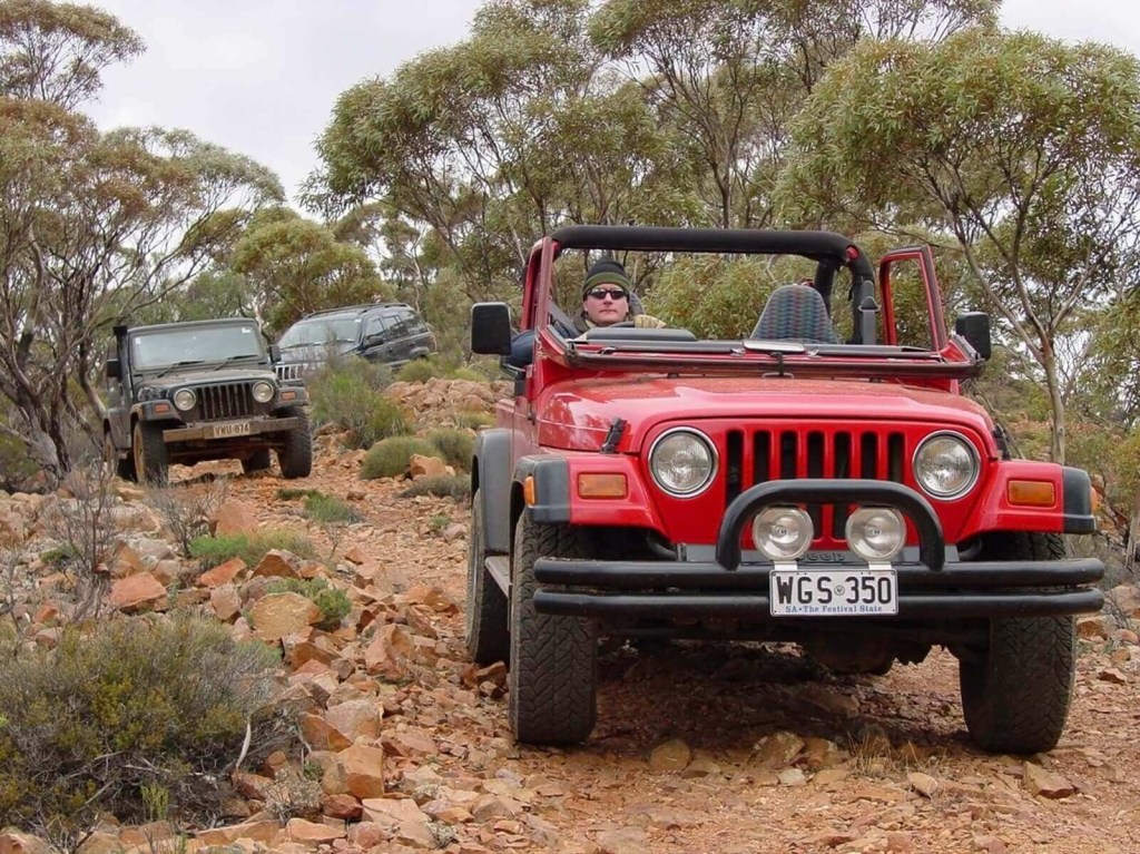 A series of right-hand drive Jeeps on a trail. 