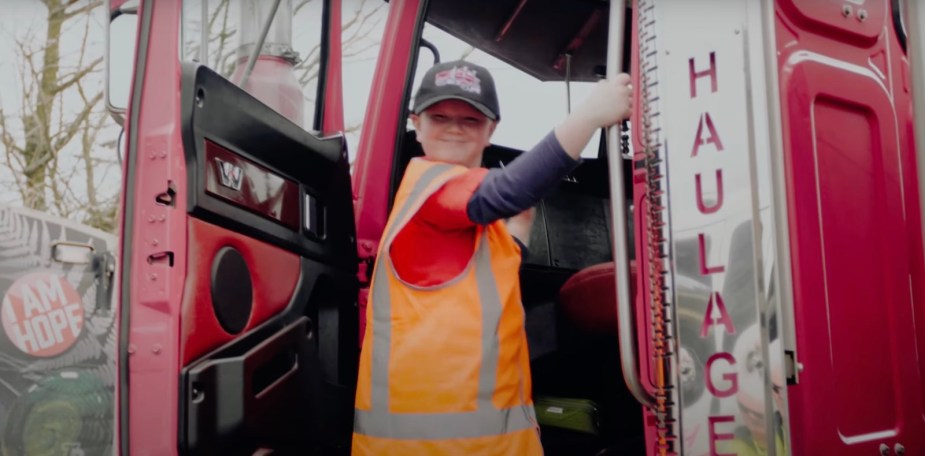 8-year-old Ollie Johnson climbs into the cab of a semi-truck in New Zealand