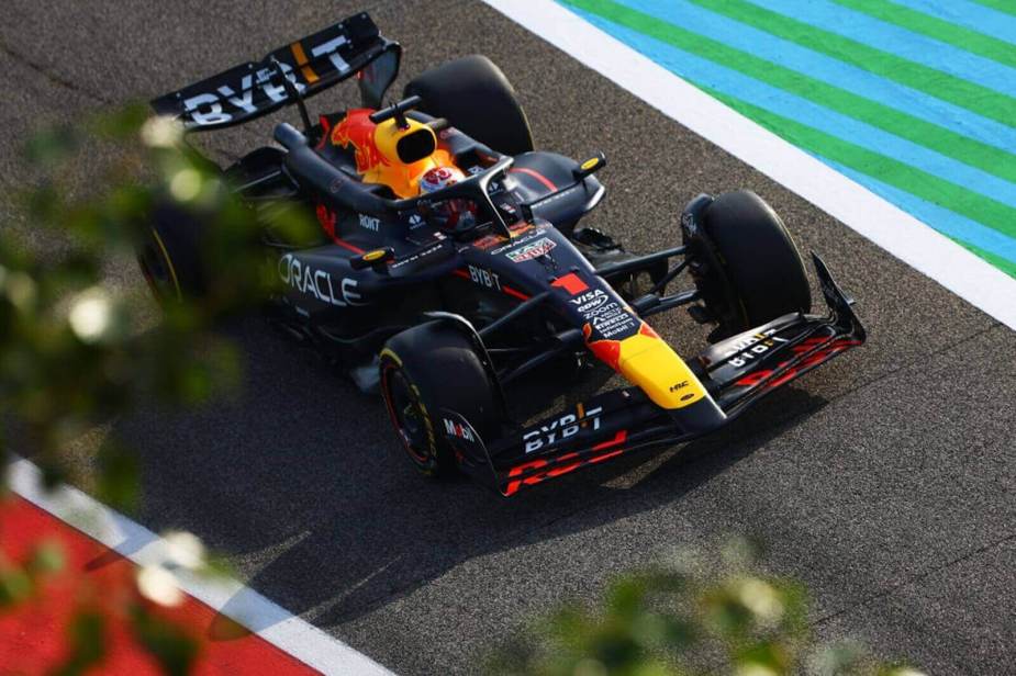 A drone captures an image of Max Verstappen driving a Red Bull F1 car.