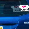 A blue Toyota Prius flashes its stickers reporting that it drives for Uber and Lyft.