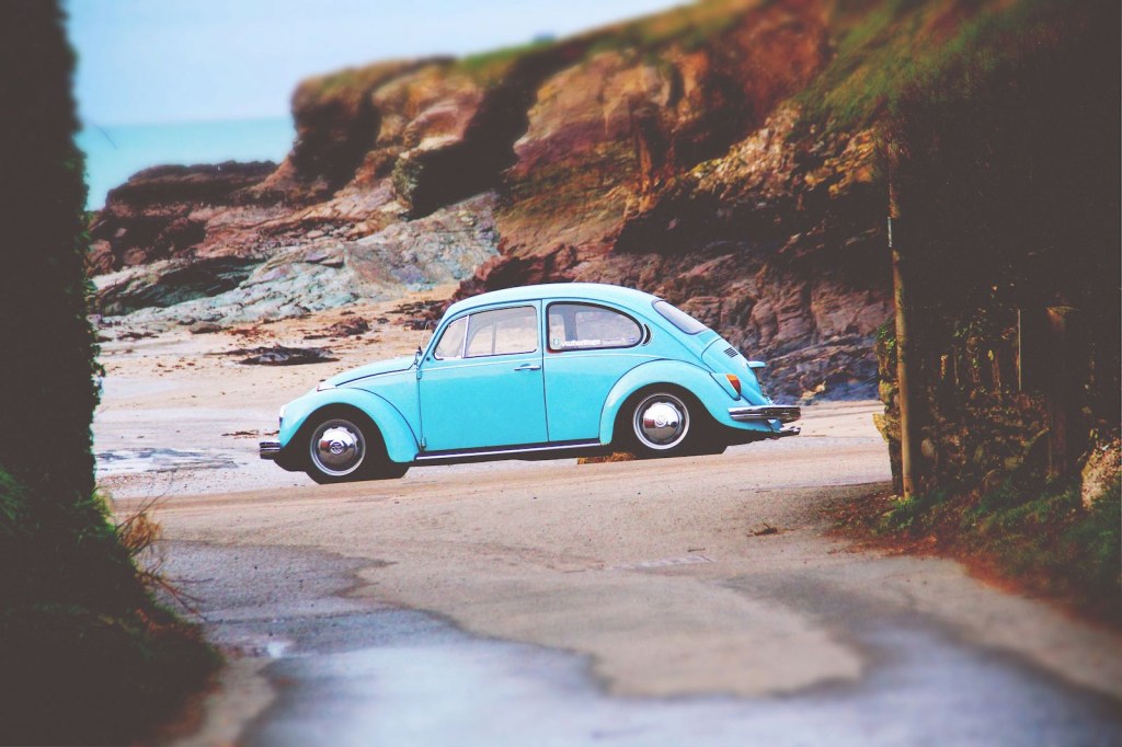 Light blue Volkswagen Beetle parked on the beach