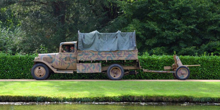 Camouflage colored Citroën Army truck pulling an anti-tank gun.
