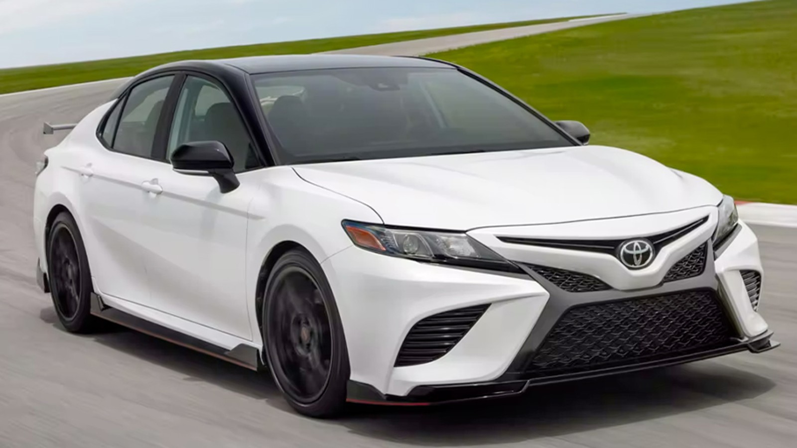 White 2024 Toyota Camry midsize sedan on a test track.