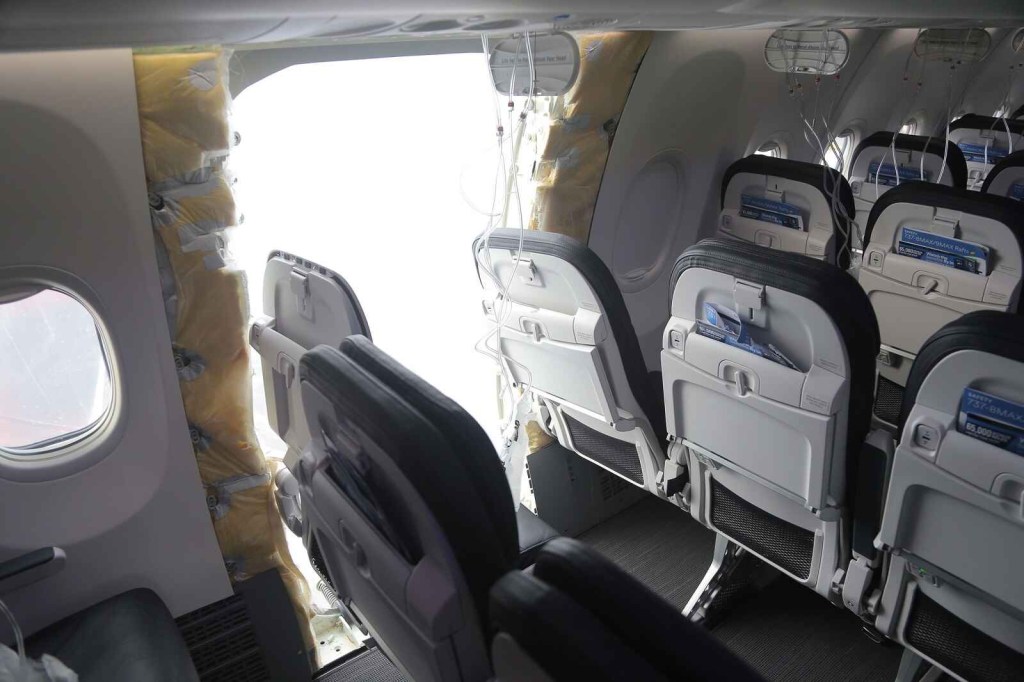 The Alaska Airlines Boeing 737 with its MED door ripped off shown from the interior cabin with damaged seats in foregound