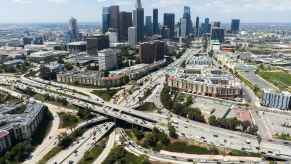 An aerial view of 'The Stack,' LA's Four-Level Freeway Interchange with Downtown LA in the background