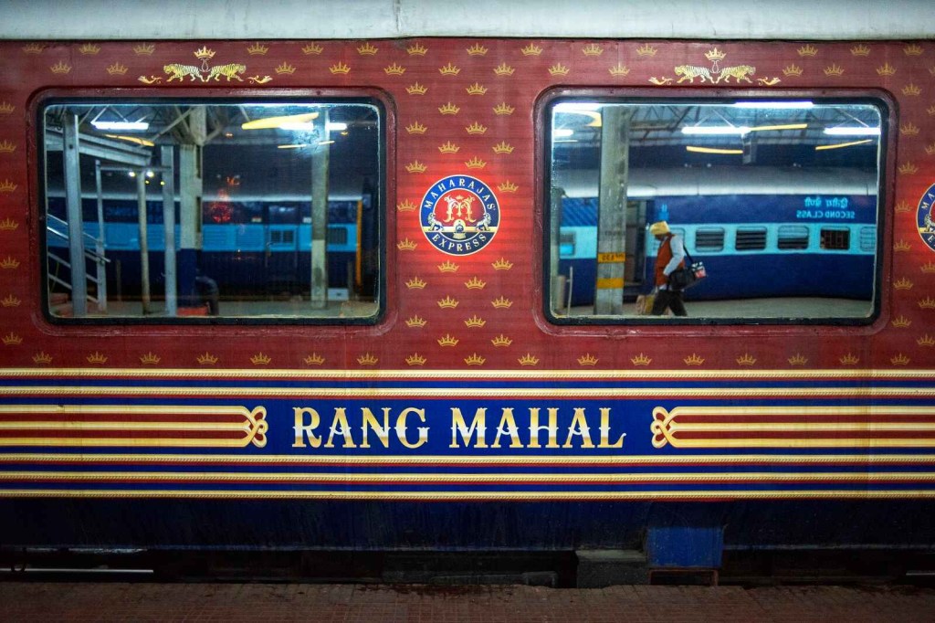 The red, gold, and blue exterior of the Maharajas's Express India's most expensive tourist train