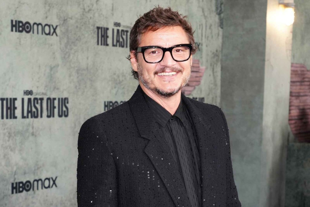 Pedro Pascal smiles for cameras at a 'The Last of Us' media event wearing black glasses and black clothing
