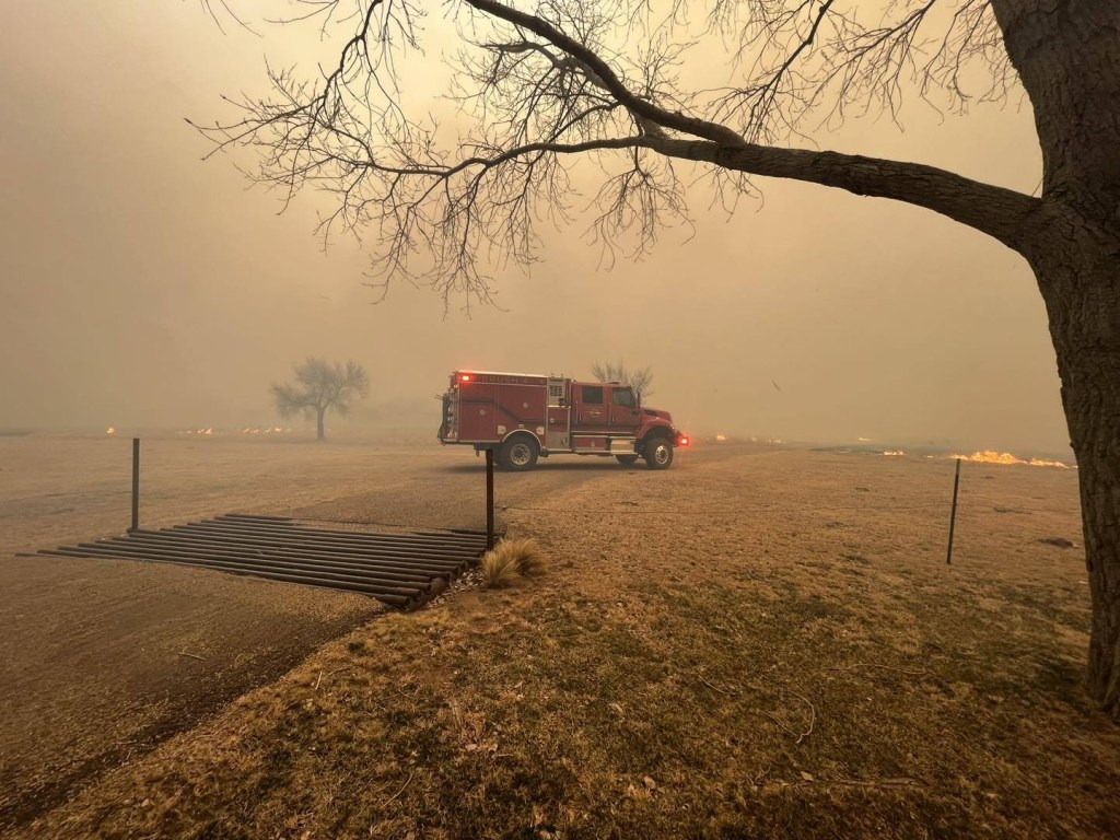 A fire truck parked in right front angle view during Texas Smokehouse Creek Fire smoggy background