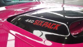 bright pink Dodge Challenger muscle car's black hood scoop with 440 Six Pack on the side