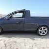 Side view of a modified VW Jetta pickup truck parked on a beach.
