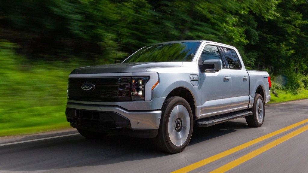 Silver 2022 Ford F-150 Lightning Platinum electric truck on the road.