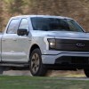 2023 Ford F-150 Lightning XLT electric truck driving on a road.