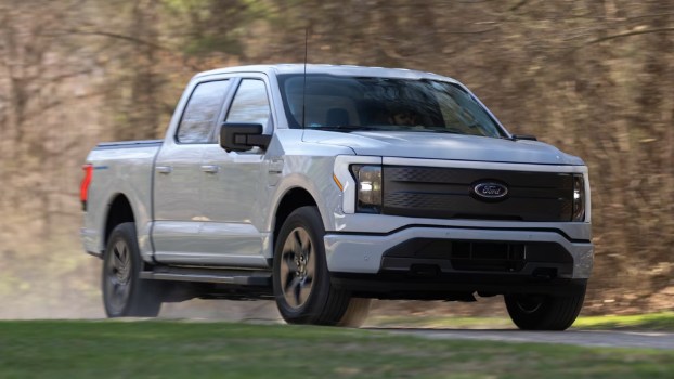 2023 Ford F-150 Lightning XLT electric truck driving on a road.