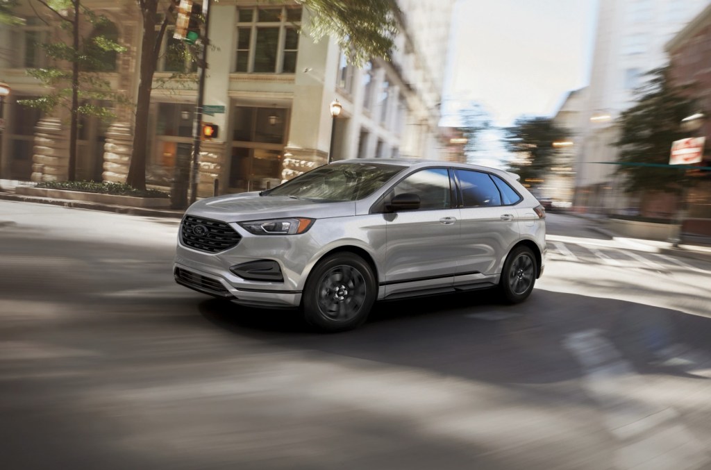 A silver 2024 Ford Edge driving on the street 