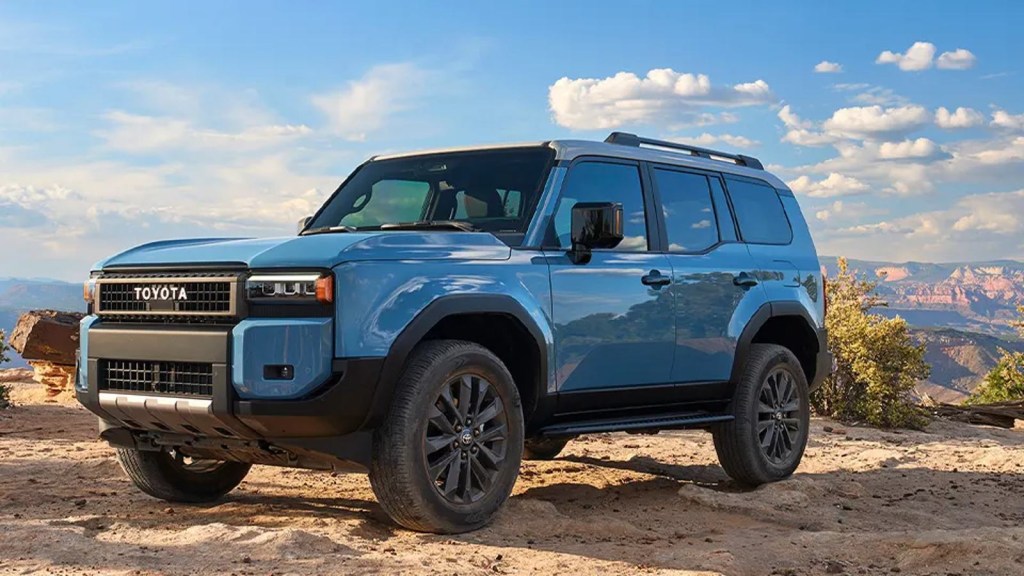 2024 Toyota Land Cruiser hybrid SUV posed on a dirt-covered trail.