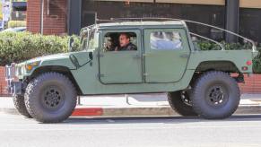 Arnold Schwarzenegger drives his Humvee with his daughter.