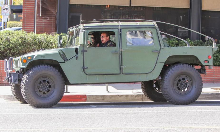 Arnold Schwarzenegger drives his Humvee with his daughter.