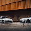 E46 generation BMW M3 parked next to a new 3 Series in front of a brick and metal building