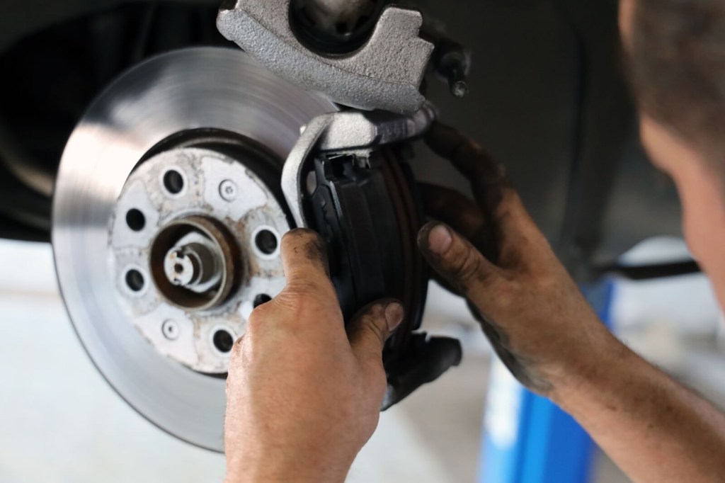 A technician replaces brake pads to stave off brake failure. 