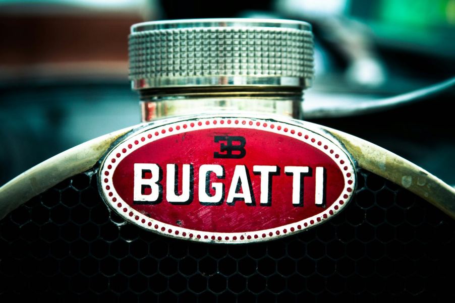 The Bugatti logo on the copper horseshoe radiator of a vintage race car.