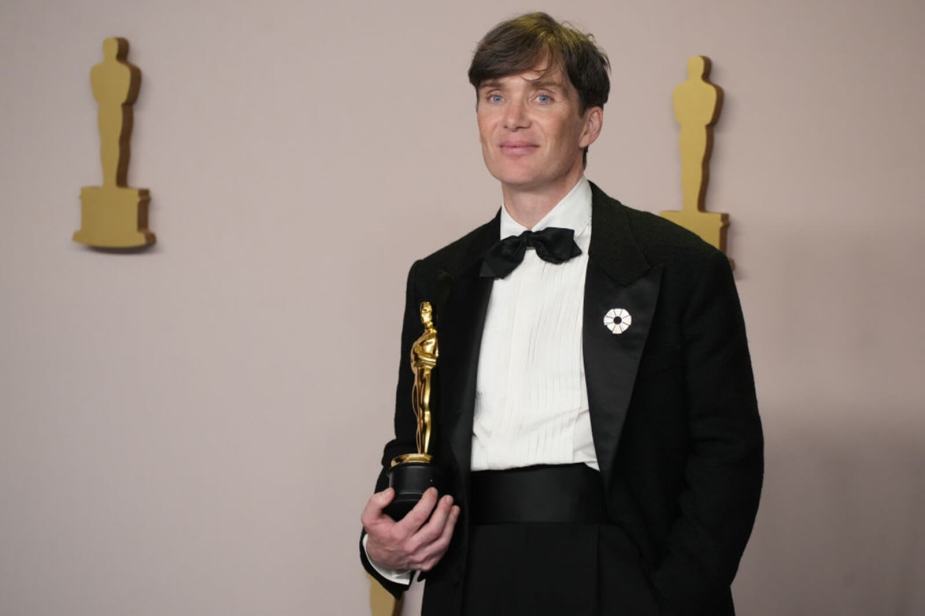 Cillian Murphy, an Oscar winner, shows off his Oscar before leaving in a car.
