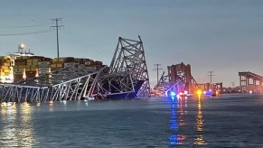 Collapsed Francis Scott Key Bridge with emergeny crews searcing for survivors in the water.
