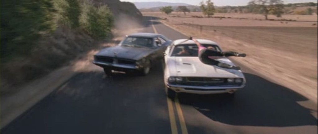 A white 1970 Dodge Challenger like the one in 'Vanishing Point', and a 1969 Dodge Charger battle in 'Death Proof'.