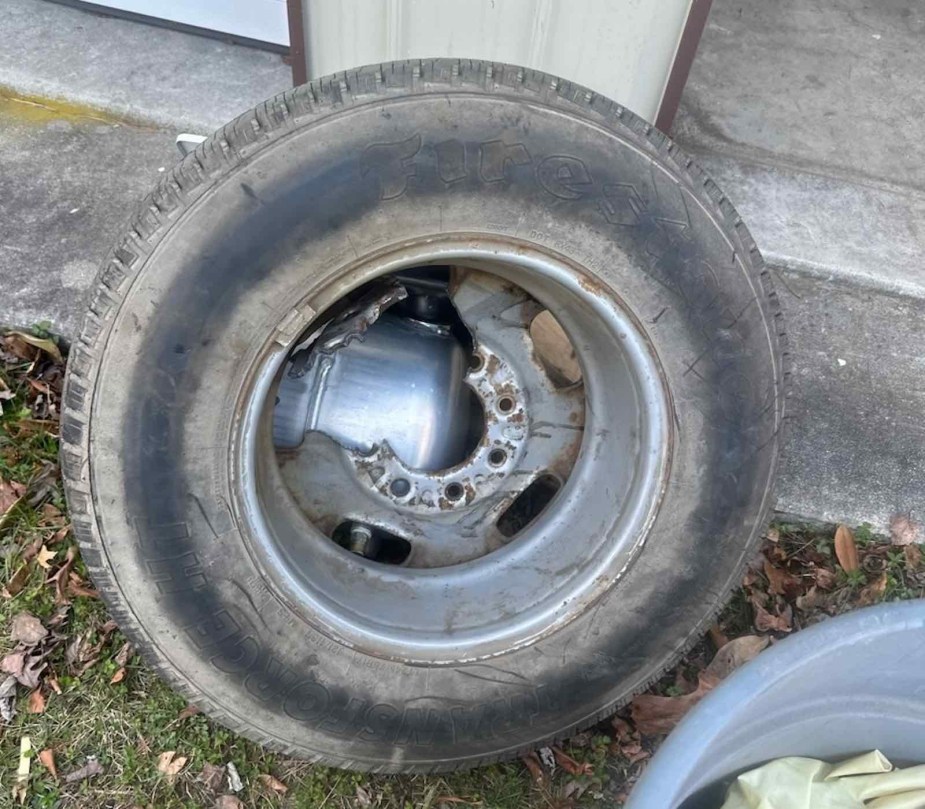 A truck spare tire rim with a section of metal cut away to free a trapped dog.