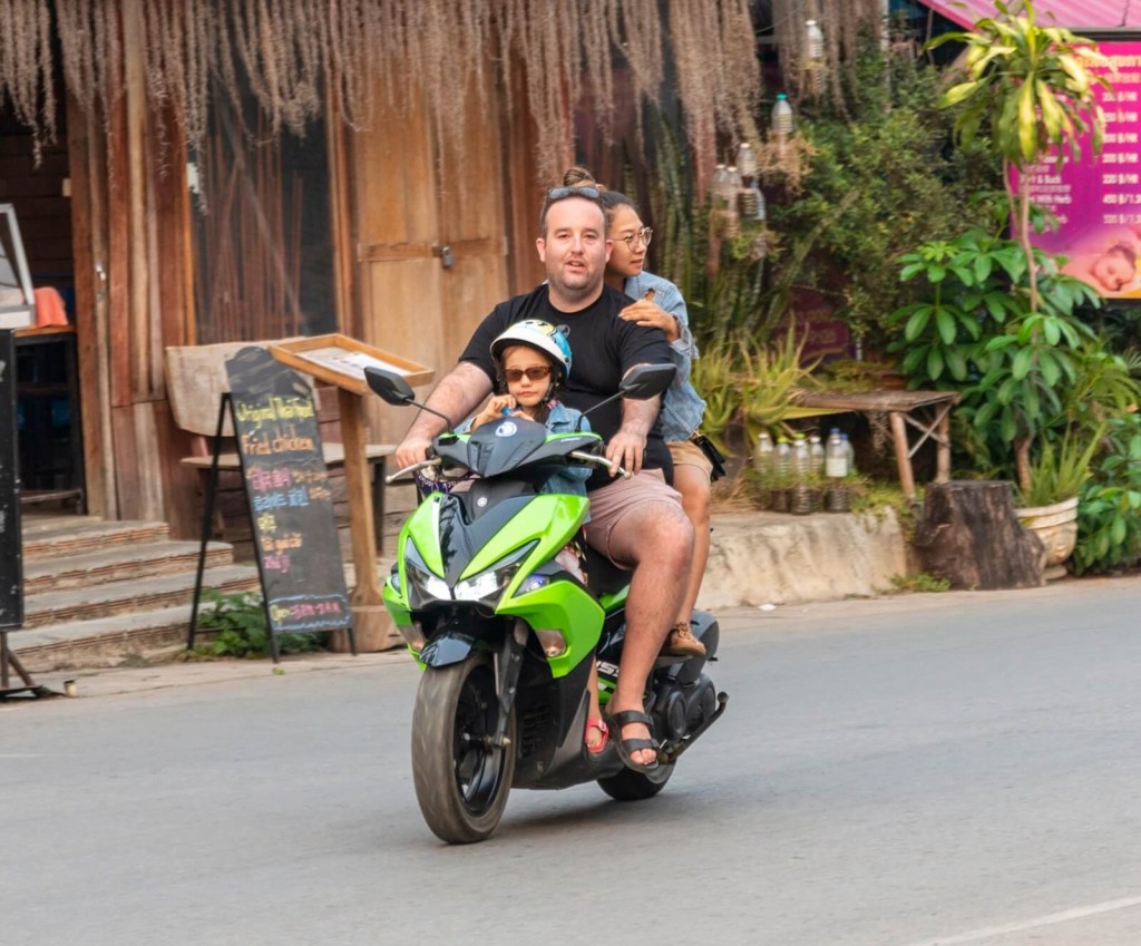 An entire family rides a motorcycle in Thailand. 